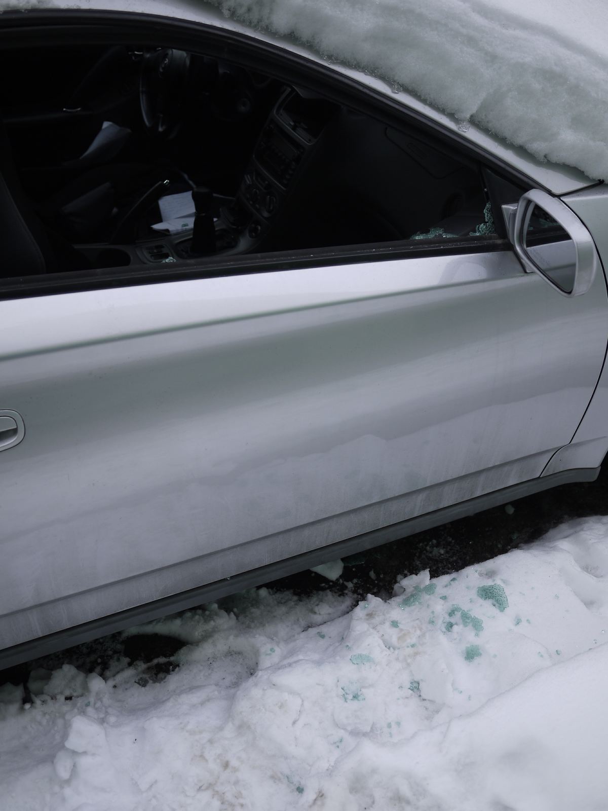 Car buried under snow and suffered a broken window